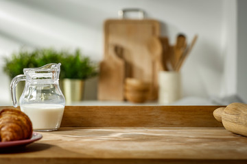 Wall Mural - wooden table in the kitchen with incoming morning sunlight with free space for an advertising produc