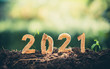 © Yuttana Studio - Happy New Year 2021 social media video.2020-2021 change background new year resolution concept.wood text on ground.Perfect for your invitation or office card