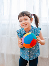 Children Little Girl Play In A Children's Game Room, Throwing Ball. Concept Of Interaction Parent And Kid