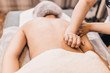 © andrey gonchar - Treatment of pain in the spine with massage - hands of a masseur on the patient back - manual therapy