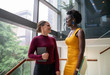© JonoErasmus - Two smiling young businesswomen talking on some office stairs