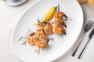 grilled shrimp on a white plate in a restaurant