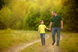 © Daria - A happy family. father and son walk along the road and hold hands for a walk in the forest.
