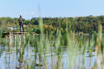 Wall Mural - A man catches a fish on a spinning fishing in the summer