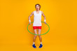 Full length body size view of nice funky slim thin comic childish foolish guy spinning plastic circle around waist having fun isolated over bright vivid shine vibrant yellow color background