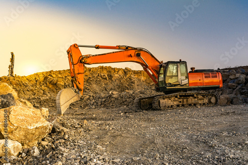 Fotomural Excavator moving stone and rock at a construction site