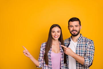 Poster - Portrait of positive cheerful team promoter woman man point index finger copyspace indicate ads promo direct way wear checkered plaid shirt isolated over bright shine color background