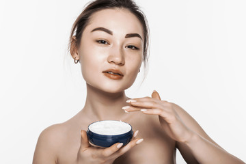 Wall Mural - Asian woman applying cosmetic cream on facial skin care face on isolated on white background