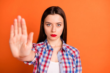 Wall Mural - Close-up portrait of her she nice attractive lovely strict serious straight-haired girl wearing checked shirt showing palm ban sign isolated over bright vivid shine vibrant orange color background