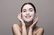 © dianagrytsku - Spa girl applying facial mask isolated on gray background. Beauty treatments.