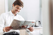 © Drobot Dean - Photo of joyful bristle businessman laughing and reading newspaper