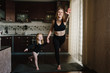 © Serhii - Mom and daughter are practicing yoga at home. Sports mom with kid doing morning work-out. Mum and child do the exercises together, healthy family lifestyle. Coronavirus Stay Home. Covid-19 lock down.