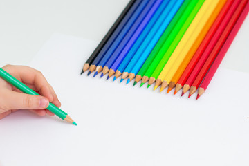 Poster - Little girl's hand drawing on blank paper with colorful pencils on white background. Copy space for text. Mockup. Selective focus.