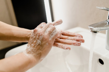  female hands wash with soap in the sink with water