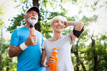 Wall Mural - Beautiful mature couple jogging in nature living healthy