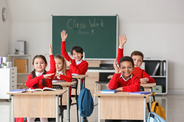 Wall Mural - Cute little pupils during lesson at school