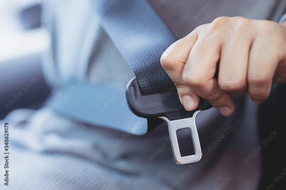 Close Up of people woman hand fastening seat safety belt in car for safety before driving on the road. concept transport travel. soft focus. - obrazy, fototapety, plakaty 