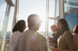 © Martin Barraud/Caia Image - Business people talking at sunny office window