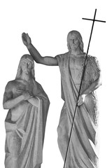 Wall Mural - Ancient stone statue of John the Baptist baptizing Jesus Christ. Black and white statue isolated on white background.