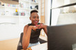 © Paul Bradbury/Caia Image - Smiling young woman working from home, using computer in home office