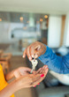 © Paul Bradbury/Caia Image - Close up man handing house keys to woman