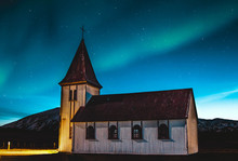 Beautiful Green And Blue Northern Lights Dancing Over A Little Village Church In Iceland.