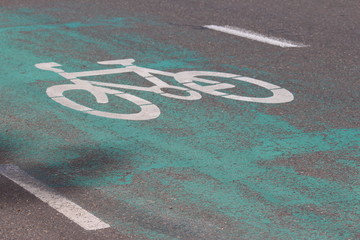 Bicycle icon painted on a bike path, the path is painted green