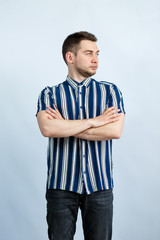 Wall Mural - Portrait of a young man in a striped shirt on a white background. Stylish guy dressed in casual style. Male image for every day