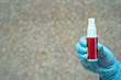 red antiseptic in hand wearing a glove. place for text. Coronavirus concept.