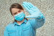 young girl has a protective mask on her face and blue gloves on her hands wants to stop the coronavirus.