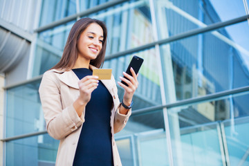 Woman near shopping mall makes an online payment