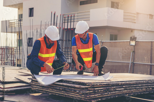 Obraz na plátně Structural engineer and architect working with blueprints discuss at the outdoors building construction site