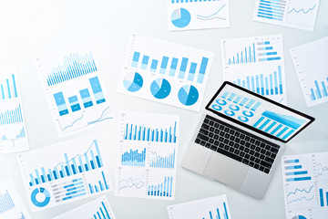 Aufkleber - Business analysis and reports. Top view of reports amd laptop on white desk. Many blue graph and chart.