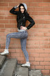 © Вячеслав Чичаев - Model posing against the backdrop of a building wall. Full-length portrait in sunny weather outdoors caucasian brunette girl with a great figure.