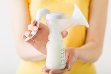 Young Mother Hands Holding Plastic Breast Pump Bottle. Closeup. Preparing Milk For Baby Feeding. Front View.