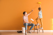 Little Son Helping His Father To Paint Wall At Home