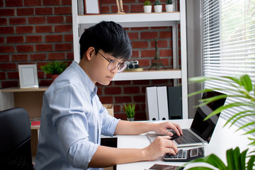 Poster - Asian businessmen are calculating numbers on the white table in the office.