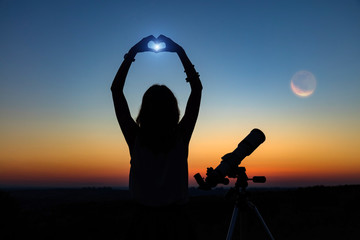 Wall Mural - silhouette of a woman and telescope with twilight sky.