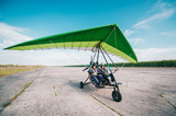 Moto hang-glider takes off on a ground airfield.