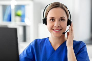 Wall Mural - medicine, technology and healthcare concept - happy smiling female doctor or nurse with headset and computer working at hospital