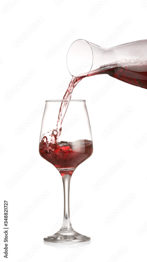 Pouring of wine from decanter into glass on white background