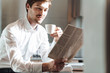 © Drobot Dean - Photo of pleased businessman drinking coffee and reading newspaper