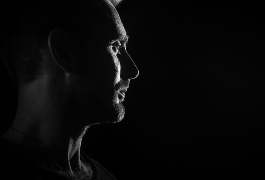 Fototapete - Dramatic profile portrait of male person on dark background