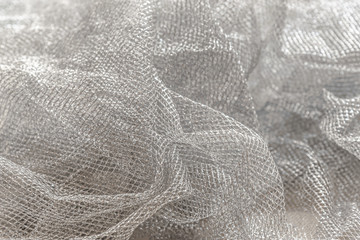 abstract background of silver mesh fabric close up