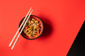 asian cuisine: noodles with seafood and veggies on red and background. horizontal. menu design template with space for text