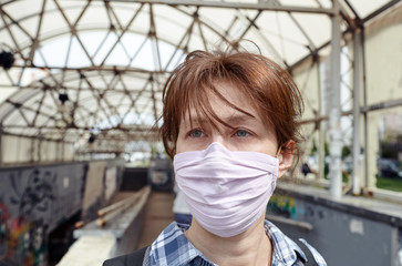 Woman wearing hygienic mask to prevent the Coronavirus. People in masks The outbreak of Novel Corona virus (2019-nCoV) in Europe. Concept of coronavirus quarantine. Air pollution