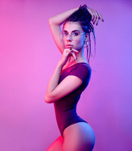 Slender Girl On A White Background Of Neon Color Posing In A Bodysuit