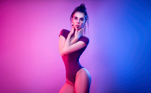 Slender Girl On A White Background Of Neon Color Posing In A Bodysuit