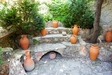 Several Clay Jugs On A Stone Base