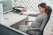 © Viacheslav Yakobchuk - Smiling pregnant woman sitting at the table at work